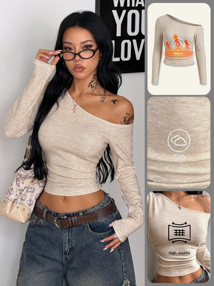 Women's slim fit long sleeve knit top featuring an asymmetrical neckline and grommet eyelet detail