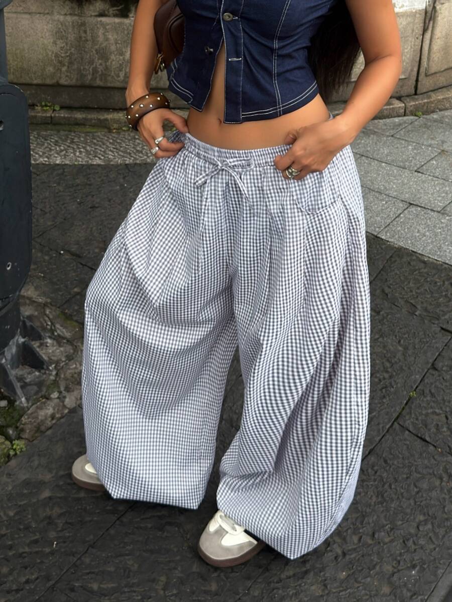 Women's loose-fit black bloomer pants made of 100% cotton featuring an elastic waistband and side pockets.