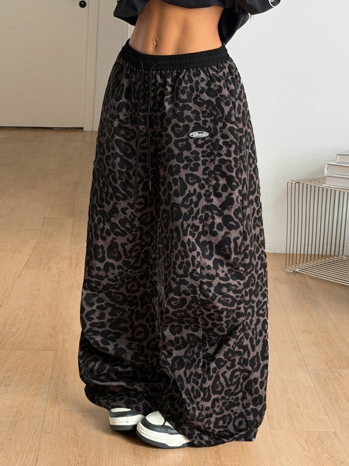 Women's black baggy jogger pants with an adjustable drawstring waist and colorblock polka dot geometric pattern.