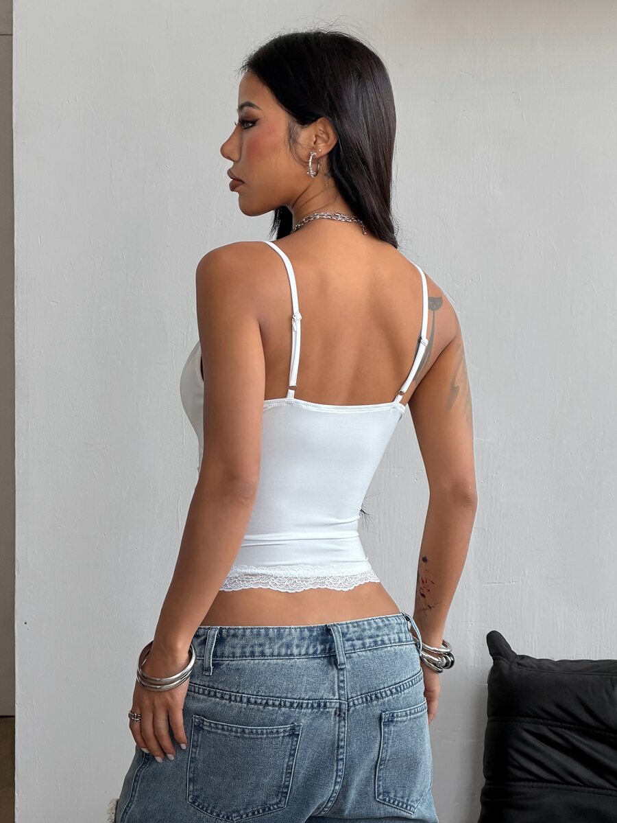 Slim fit cropped camisole top for women featuring contrast lace trim, ruched cup detailing, and delicate spaghetti straps.