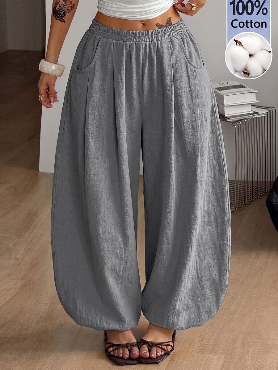 Women's loose-fit black bloomer pants made of 100% cotton featuring an elastic waistband and side pockets.