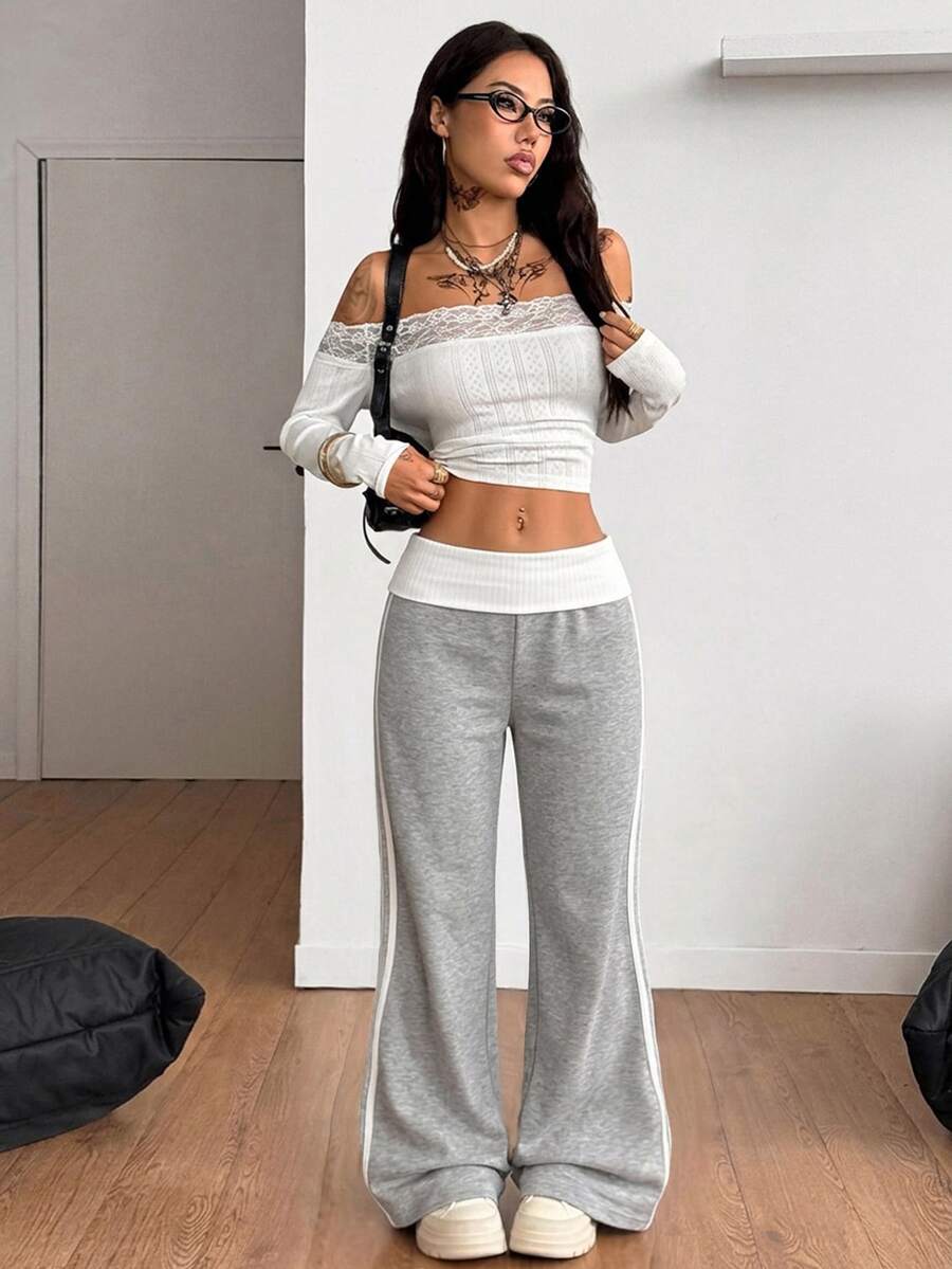 Women's wide leg flare sweatpants featuring a black and white colorblock contrast fold waistband and side stripe details.