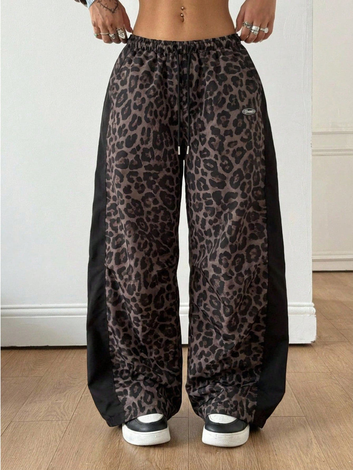 Women's black baggy jogger pants with an adjustable drawstring waist and colorblock polka dot geometric pattern.