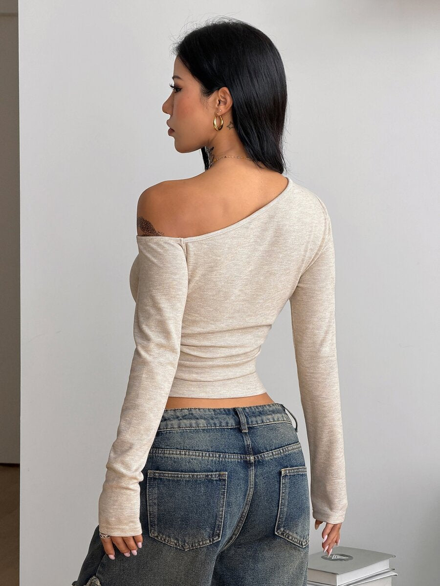 Women's slim fit long sleeve knit top featuring an asymmetrical neckline and grommet eyelet detail
