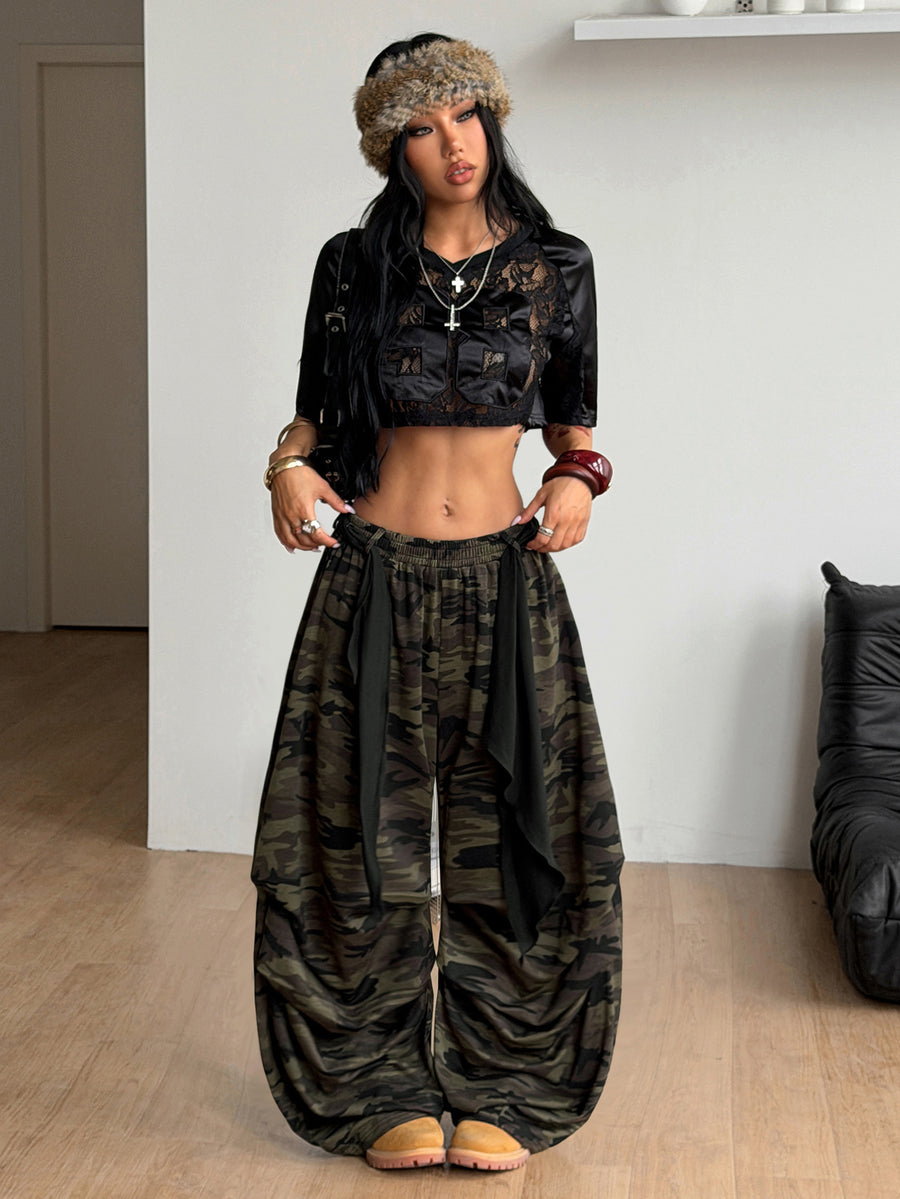 Loose-fitting black baggy parachute pants featuring an elastic drawstring waistband and wide-leg cut made from cotton blend fabric.