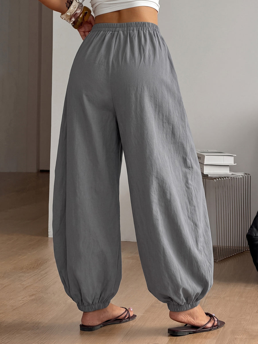 Women's loose-fit black bloomer pants made of 100% cotton featuring an elastic waistband and side pockets.