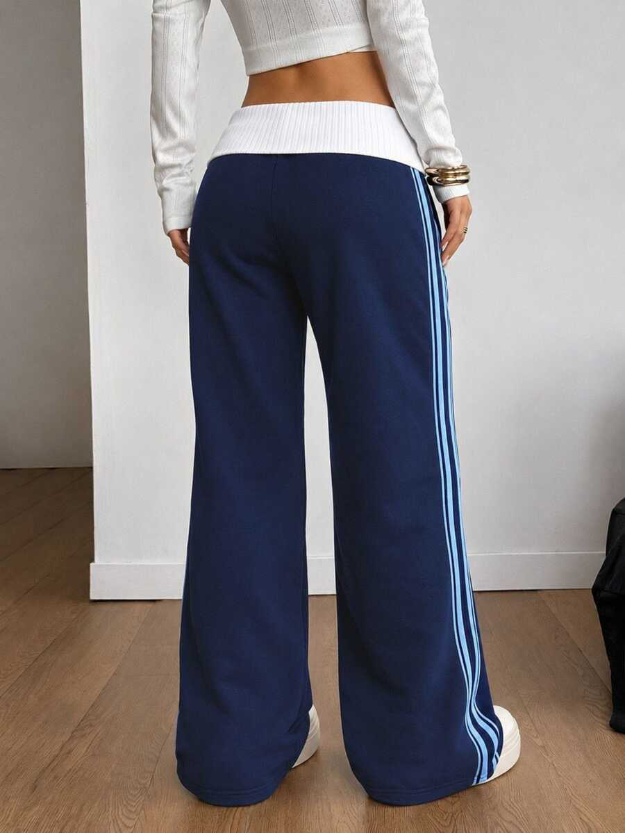 Women's wide leg flare sweatpants featuring a black and white colorblock contrast fold waistband and side stripe details.