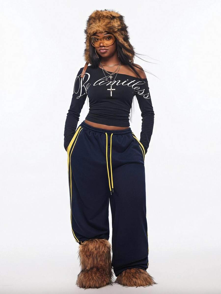 Women's slim fit long sleeve knit top featuring an asymmetrical neckline and grommet eyelet detail