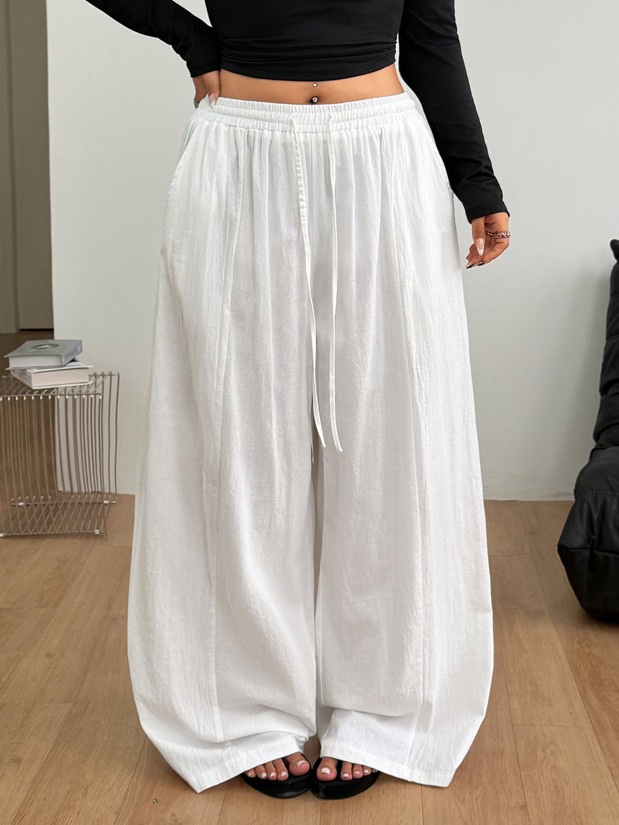 Women's loose straight leg cotton pants featuring a high waist with an adjustable drawstring knot and functional side pockets.