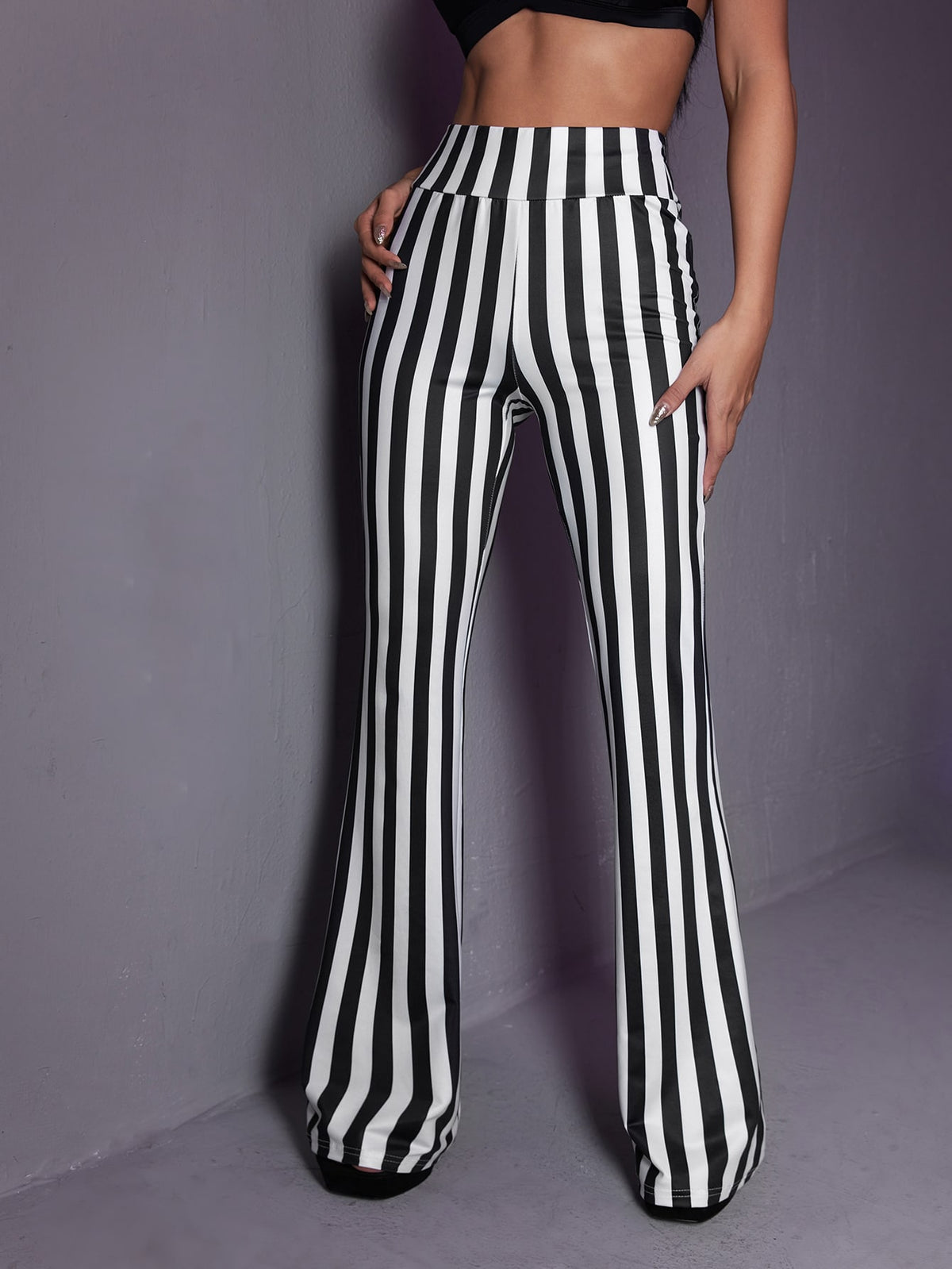 Women's black and white striped flare leg pants featuring a high elastic waist and extra long cut.