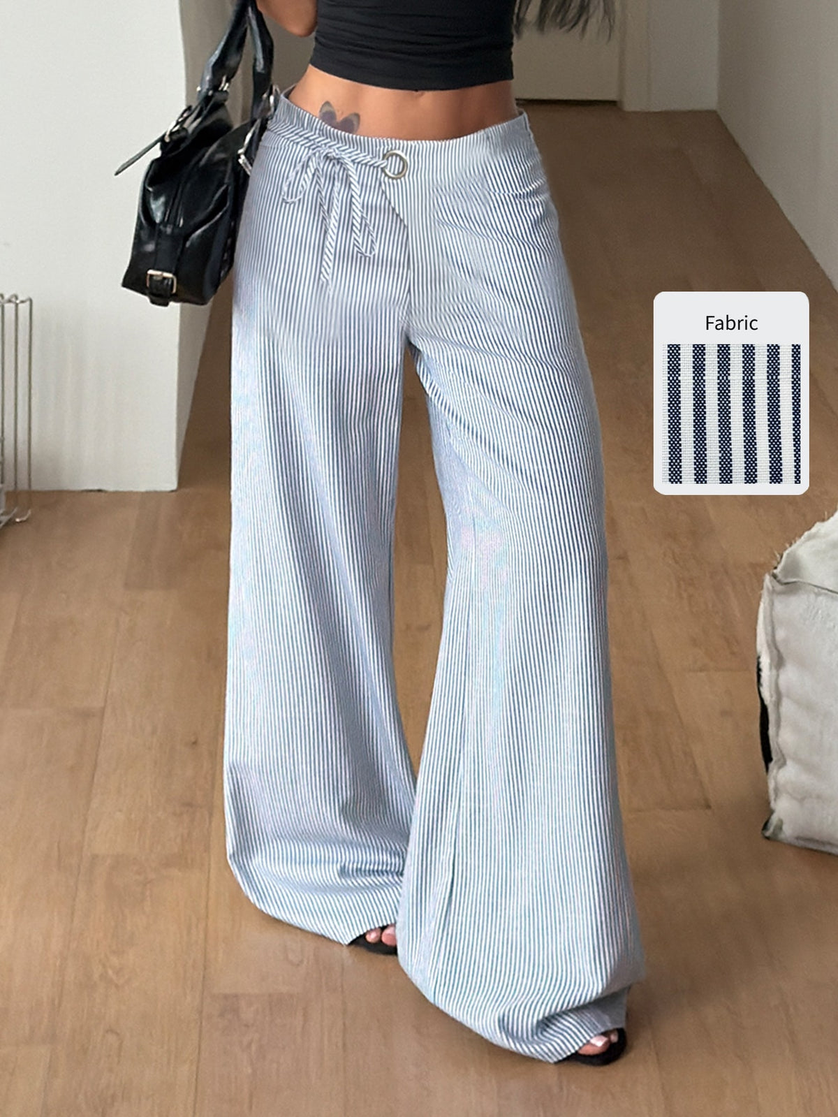 Women's blue and white striped woven wide leg long pants featuring side knot ties and grommet eyelet details.