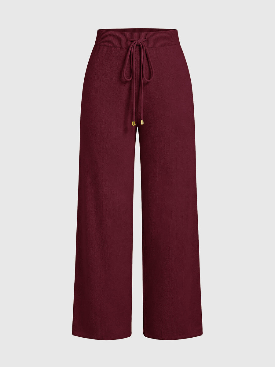 Women's two-piece rib-knit sweater set featuring a long-sleeve cold-shoulder crop top with strap details and matching wide-leg pants.