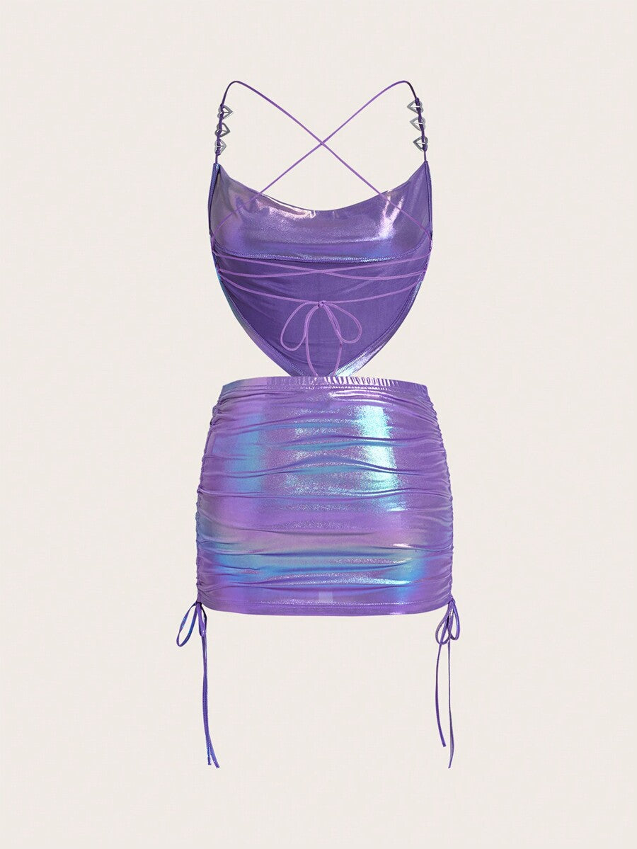 Holographic metallic two-piece set with a spaghetti strap hanky hem crop cami top and drawstring side skirt, featuring ruched details and rhinestone accents.