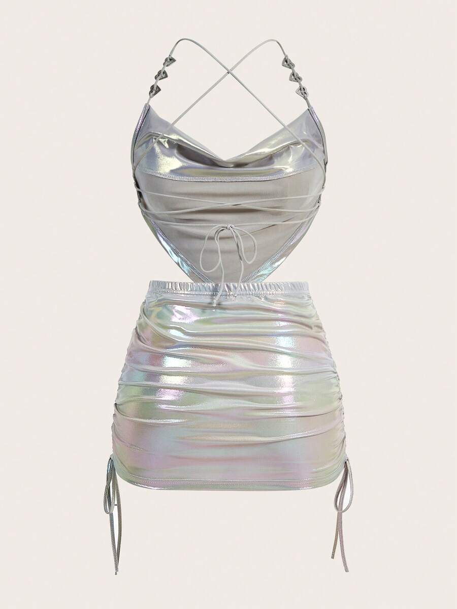 Holographic metallic two-piece set with a spaghetti strap hanky hem crop cami top and drawstring side skirt, featuring ruched details and rhinestone accents.