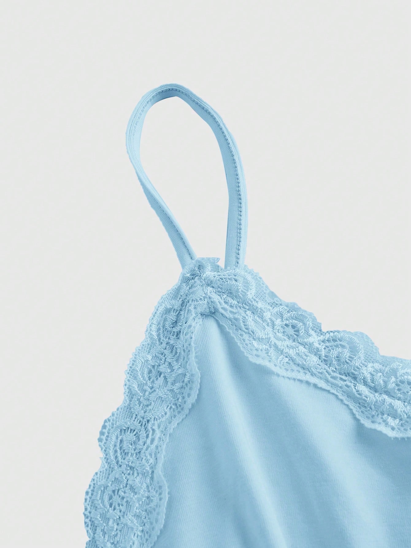 Women's spaghetti strap camisole with contrast lace patchwork, slim fit silhouette, plain design, and flared hem.