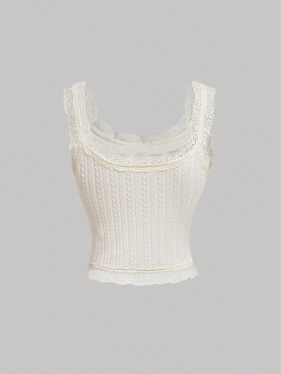 Black jacquard textured camisole top featuring contrast lace trim, bow decoration, scoop neck, and wide shoulder straps.