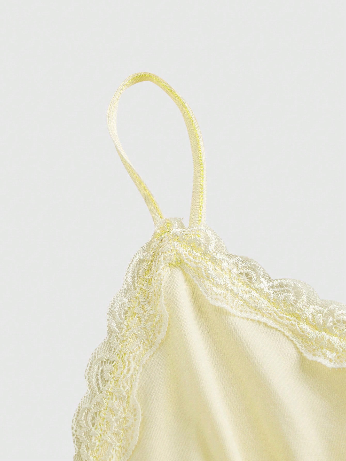 Women's spaghetti strap camisole with contrast lace patchwork, slim fit silhouette, plain design, and flared hem.