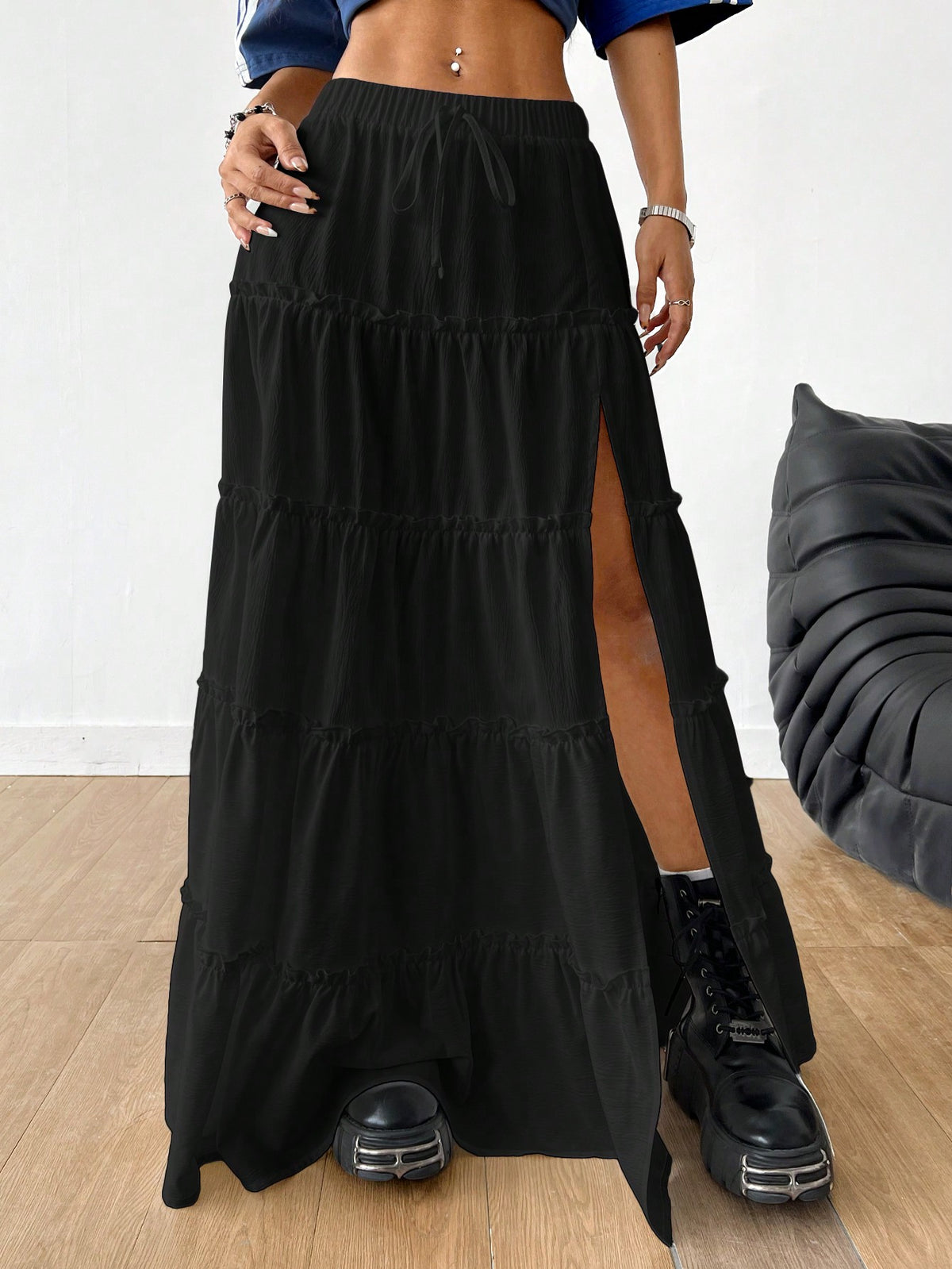 Women's black maxi bubble skirt featuring a high thigh split, lettuce ruffle trim, and a relaxed flared silhouette.