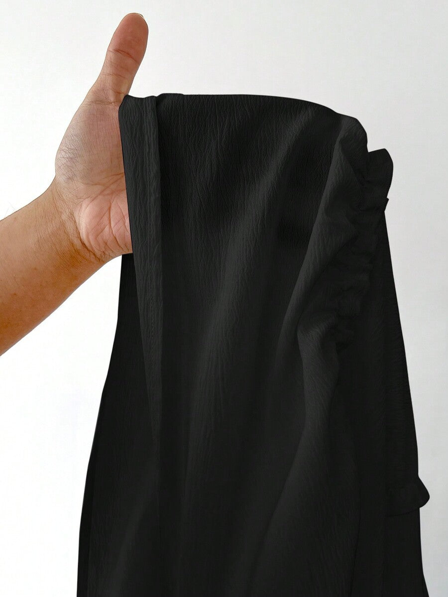 Women's black maxi bubble skirt featuring a high thigh split, lettuce ruffle trim, and a relaxed flared silhouette.