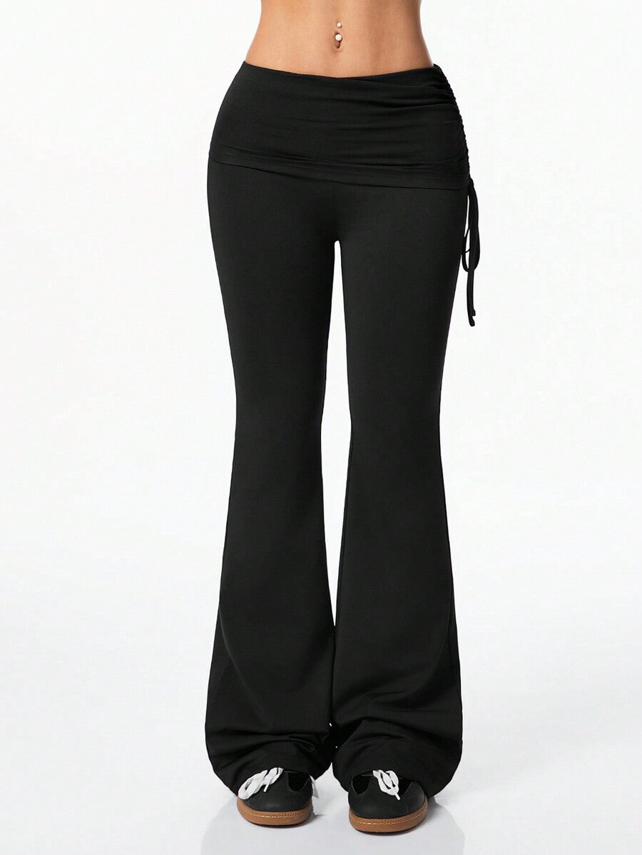 Women's black and white polka dot flare leg pants with side drawstring and ruched details