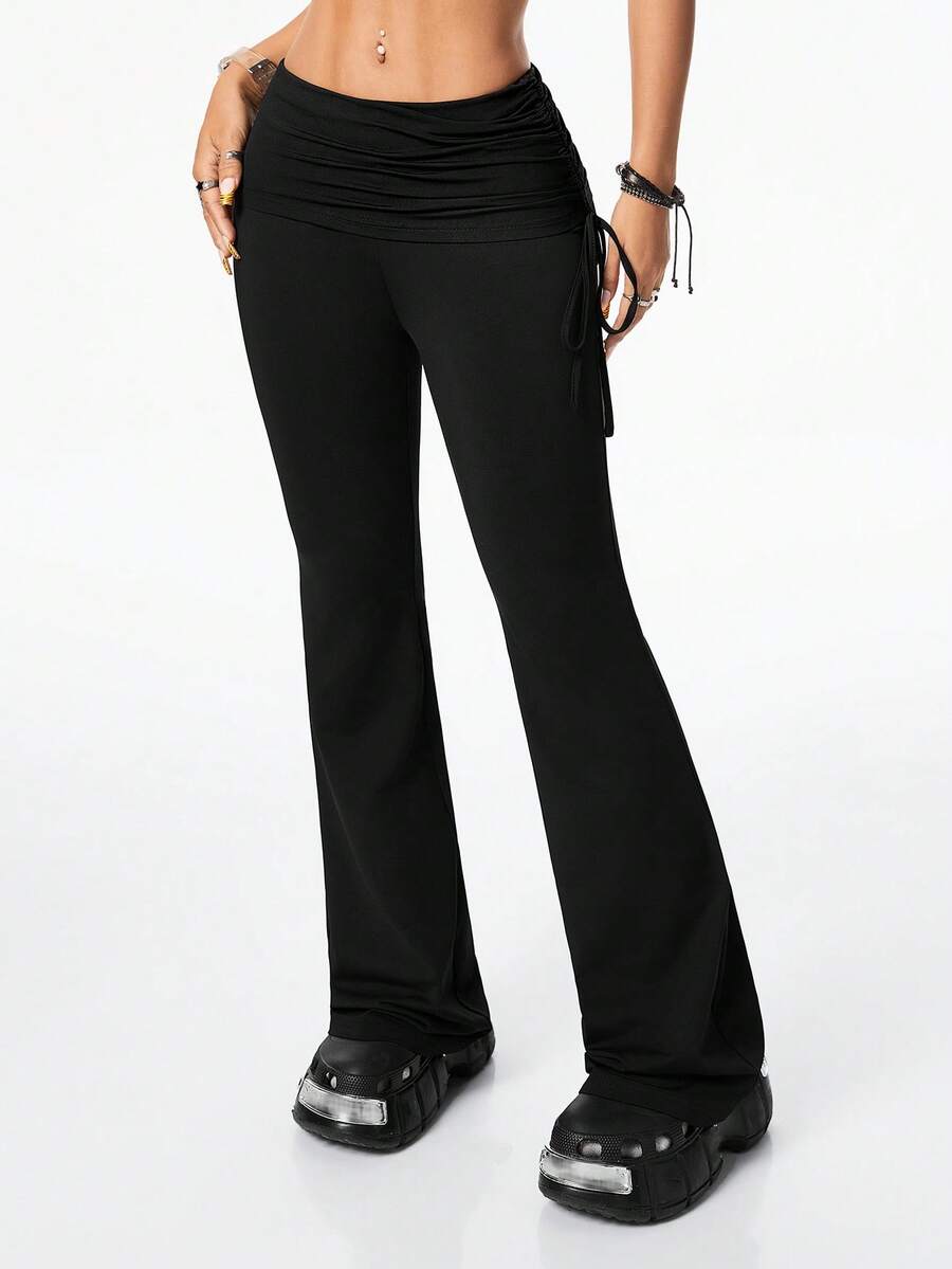 Women's black and white polka dot flare leg pants with side drawstring and ruched details