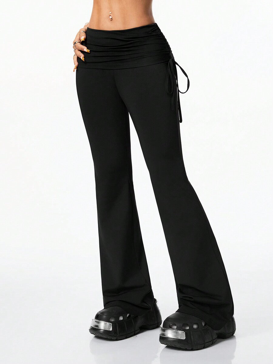 Women's black and white polka dot flare leg pants with side drawstring and ruched details