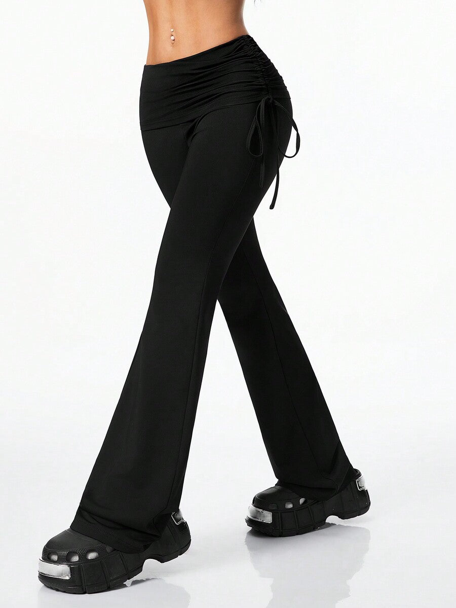 Women's black and white polka dot flare leg pants with side drawstring and ruched details