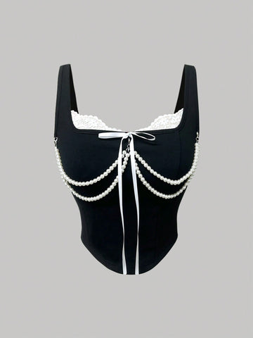 women's black wide-strap tank top featuring a lace collar, detachable bow chain decor with pearl details, and an asymmetrical hem.