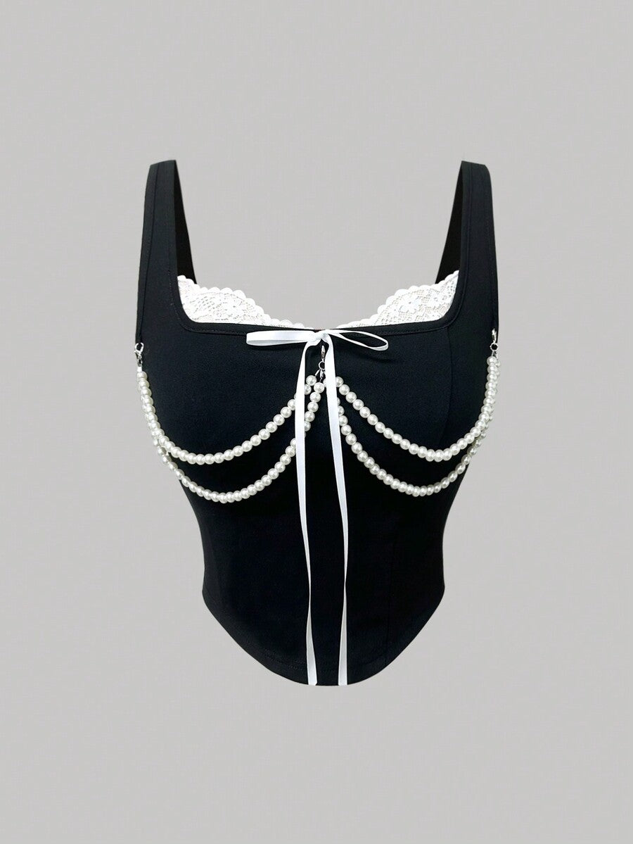 women's black wide-strap tank top featuring a lace collar, detachable bow chain decor with pearl details, and an asymmetrical hem.