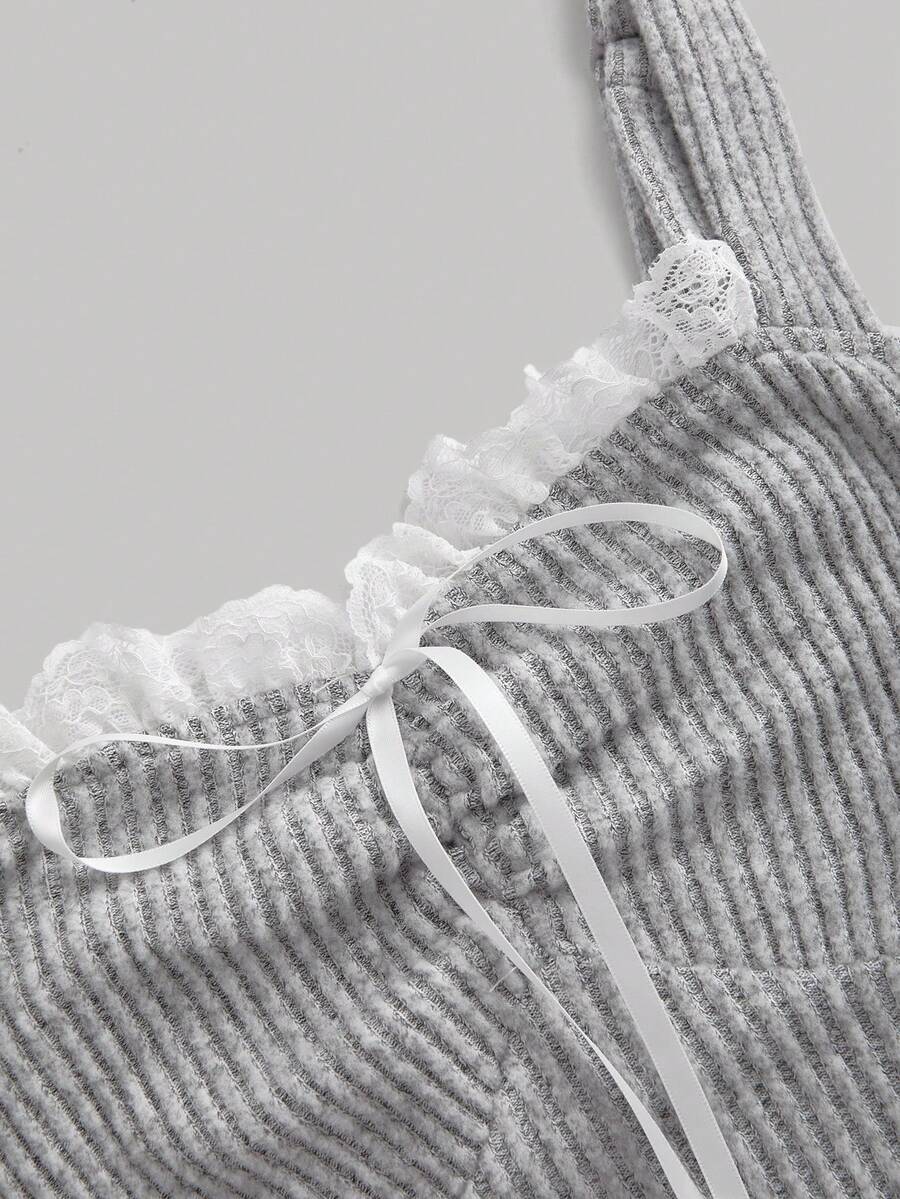 Black crop camisole top for women featuring shoulder straps, cold shoulder sleeves, drawstring detail, and frill trim on plain knitted fabric.