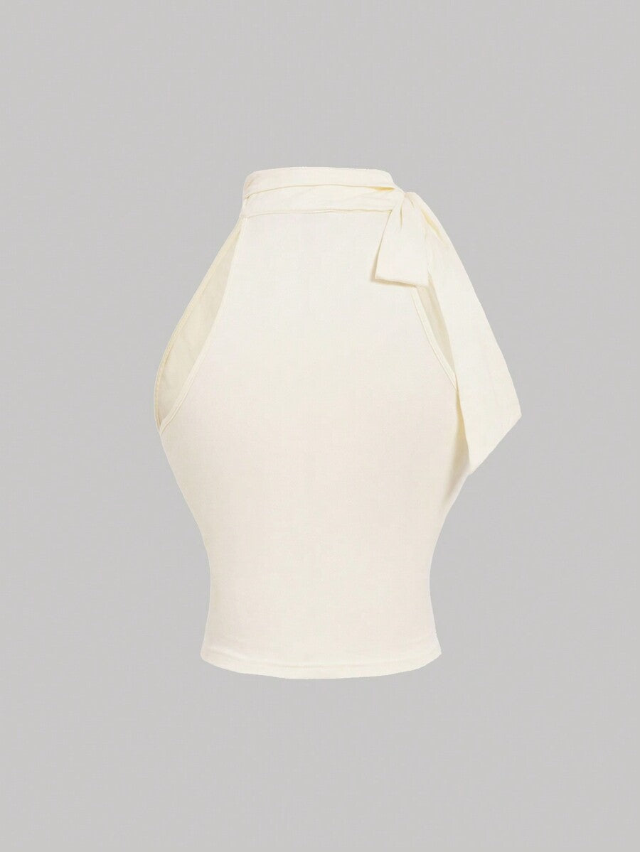 Women's sleeveless high-neck halter crop top in apricot with ruched knot front detailing.