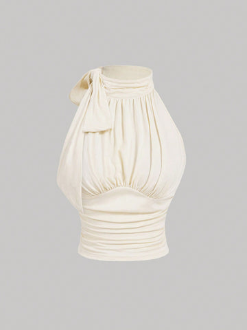Women's sleeveless high-neck halter crop top in apricot with ruched knot front detailing.