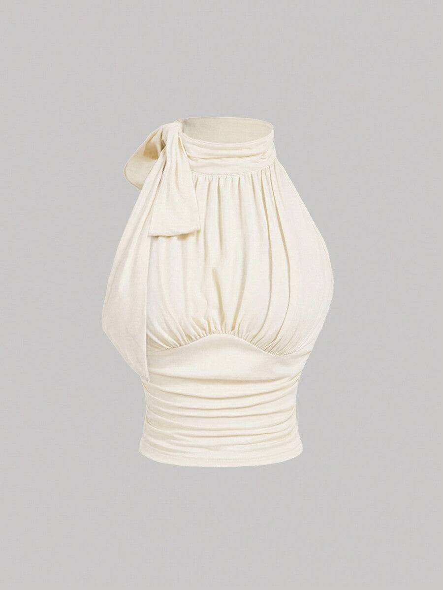 Women's sleeveless high-neck halter crop top in apricot with ruched knot front detailing.