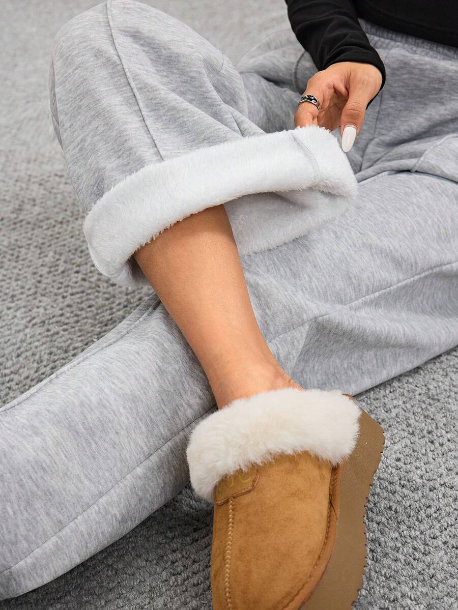 Women's grey fleece straight-leg sweatpants featuring a loose fit and elastic waistband.