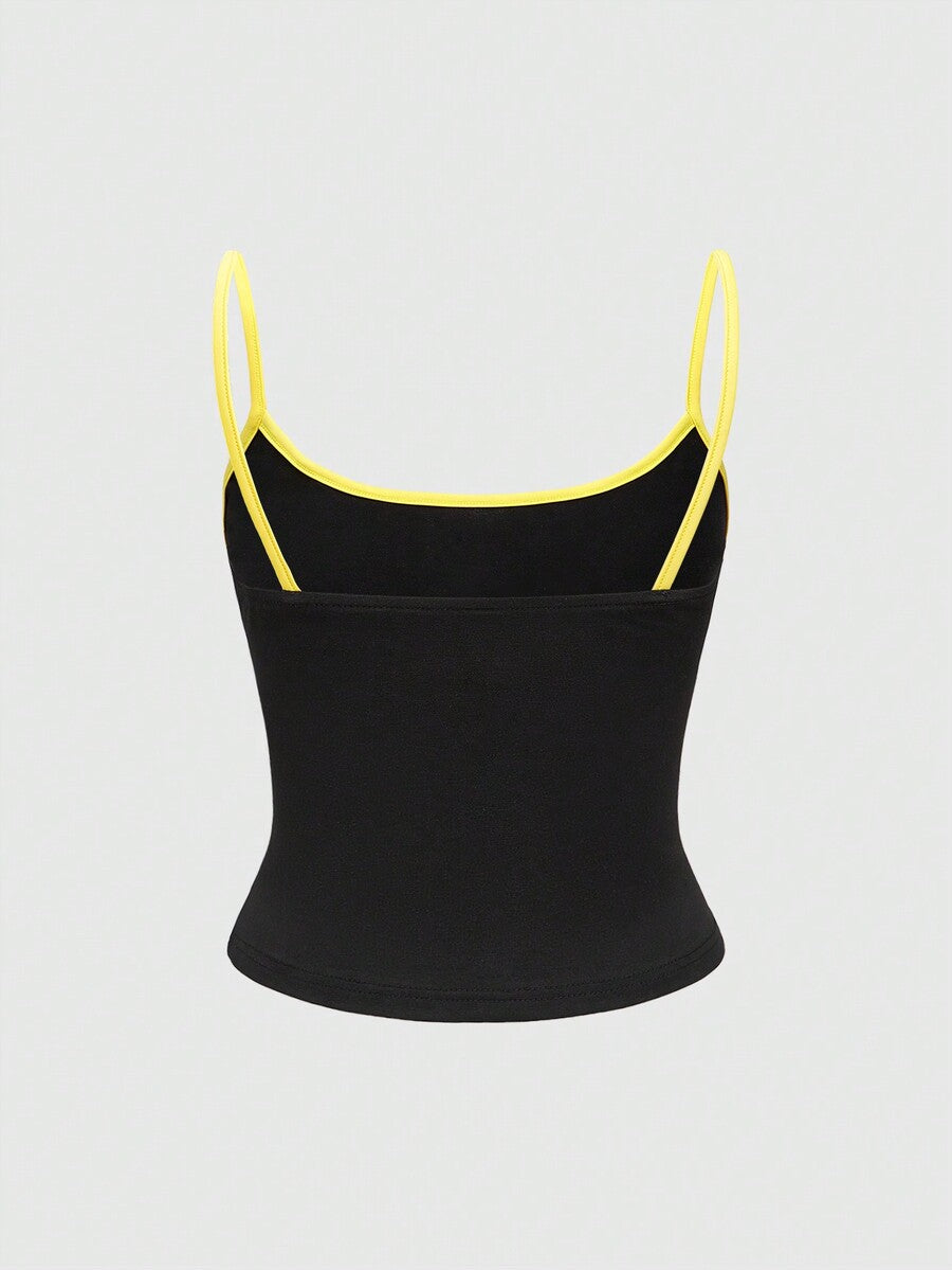 Black cropped cami top featuring a graphic print, spaghetti straps, rib-knit fabric with contrast binding, and a slim fit silhouette.