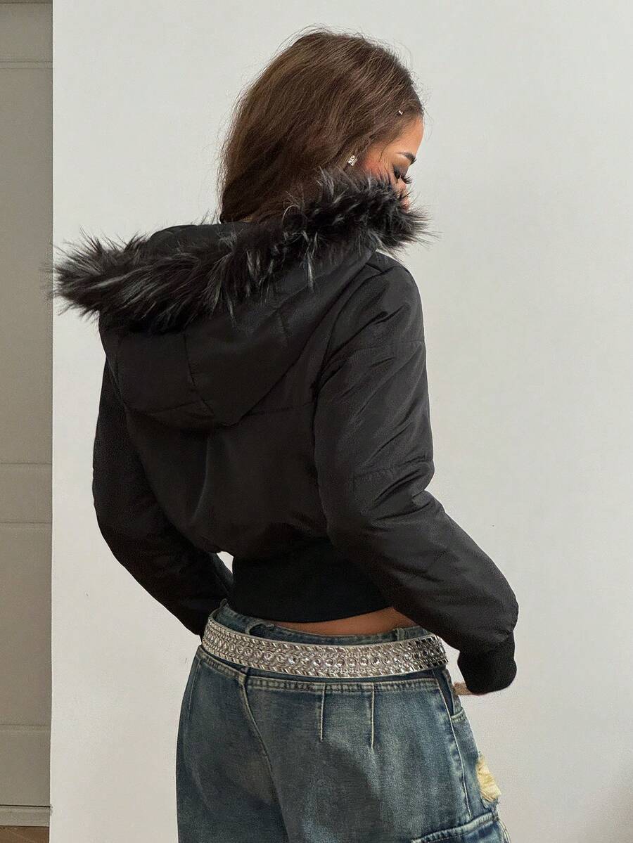 Women's brown cropped puffer jacket featuring a faux fur trimmed hood, front zipper, and ribbed hem.