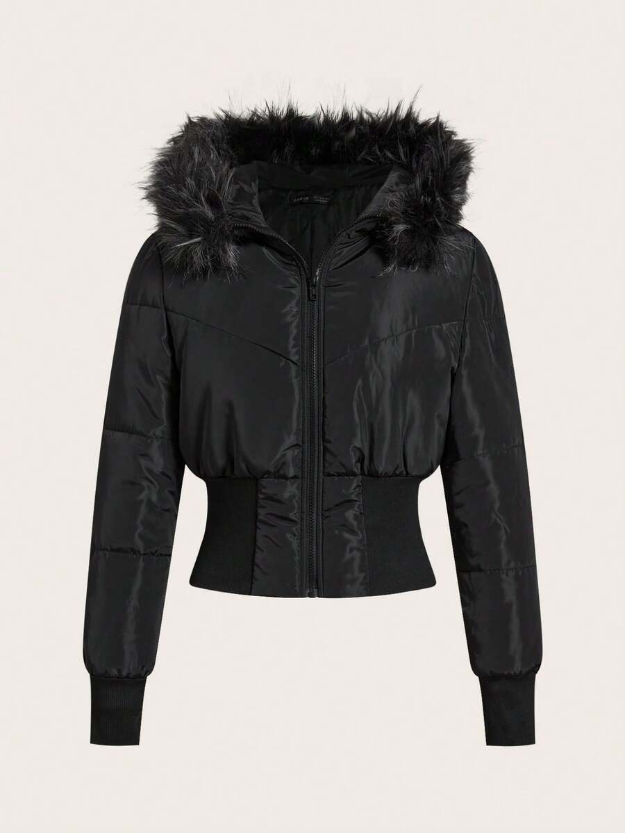 Women's brown cropped puffer jacket featuring a faux fur trimmed hood, front zipper, and ribbed hem.