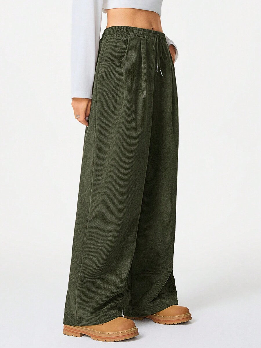 Women's loose fit brown and tan plaid wide leg pants featuring an elastic drawstring waist and side pockets.