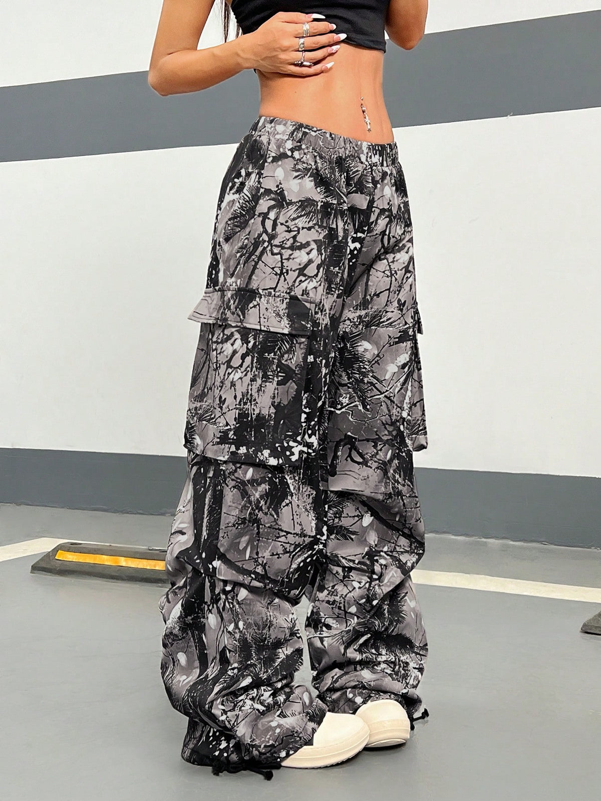 Women's high waist wide leg cargo pants featuring a black and white tree branch print and adjustable drawstring closure.