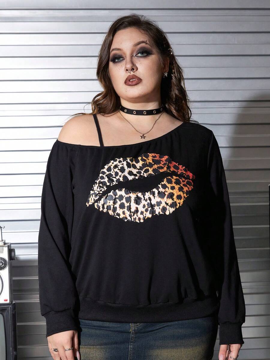 Black women's loose long sleeve gothic sweatshirt with an asymmetrical neckline, strap detail, and fang graphic print.