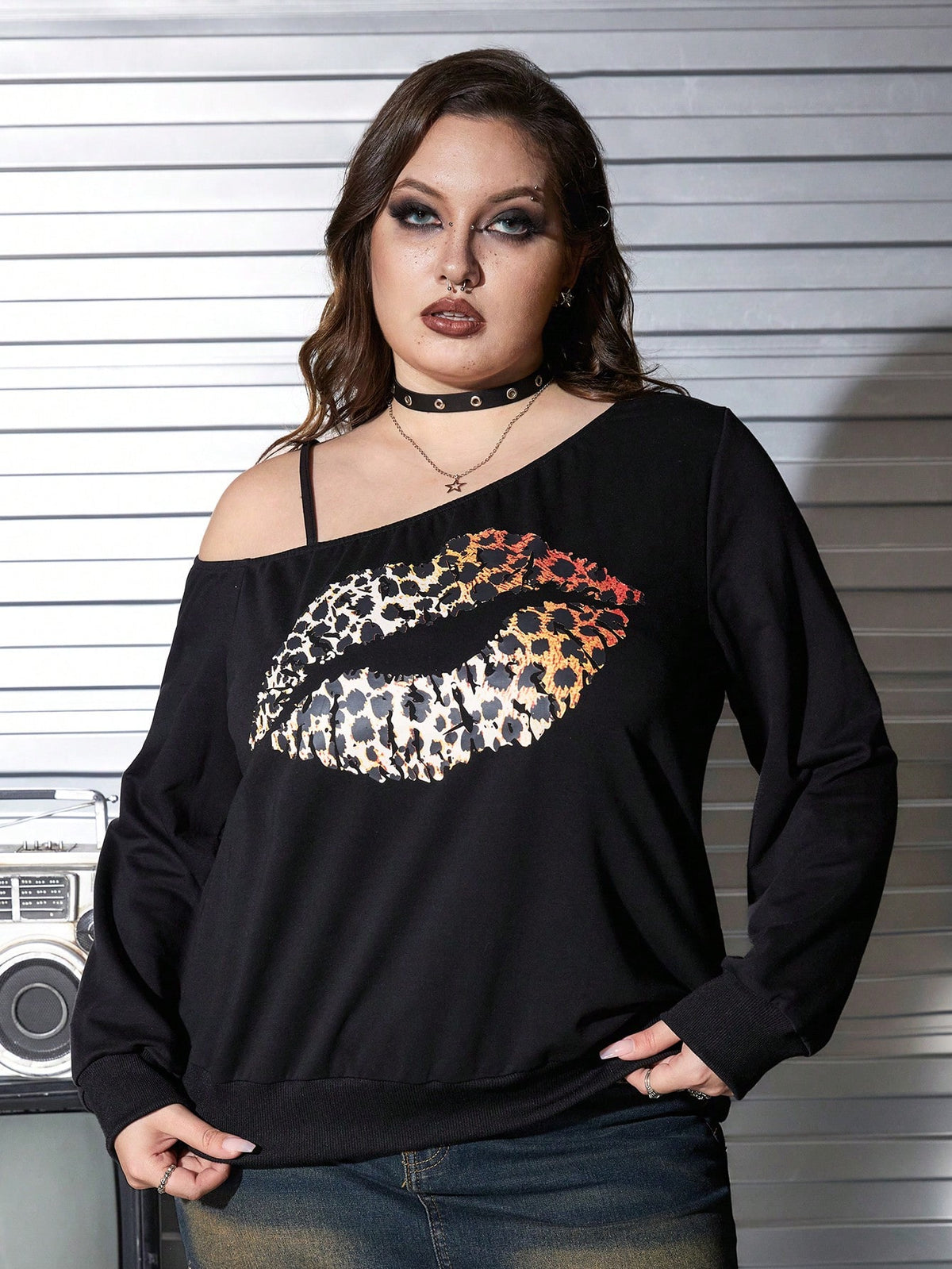 Black women's loose long sleeve gothic sweatshirt with an asymmetrical neckline, strap detail, and fang graphic print.