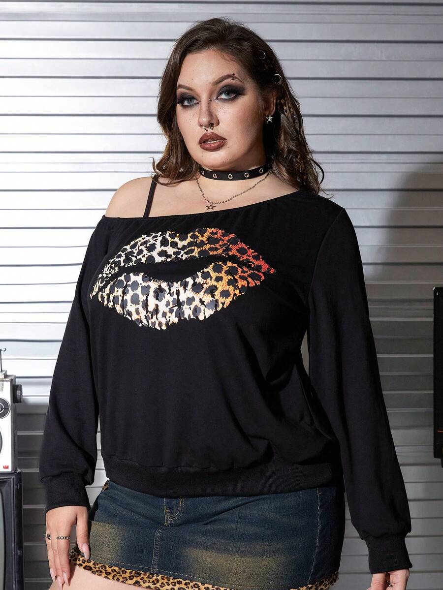 Black women's loose long sleeve gothic sweatshirt with an asymmetrical neckline, strap detail, and fang graphic print.