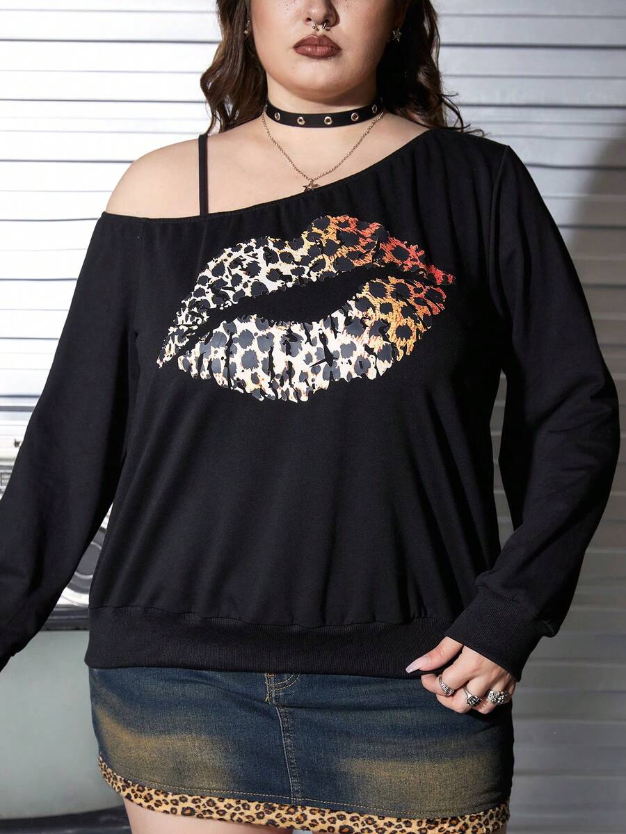 Black women's loose long sleeve gothic sweatshirt with an asymmetrical neckline, strap detail, and fang graphic print.