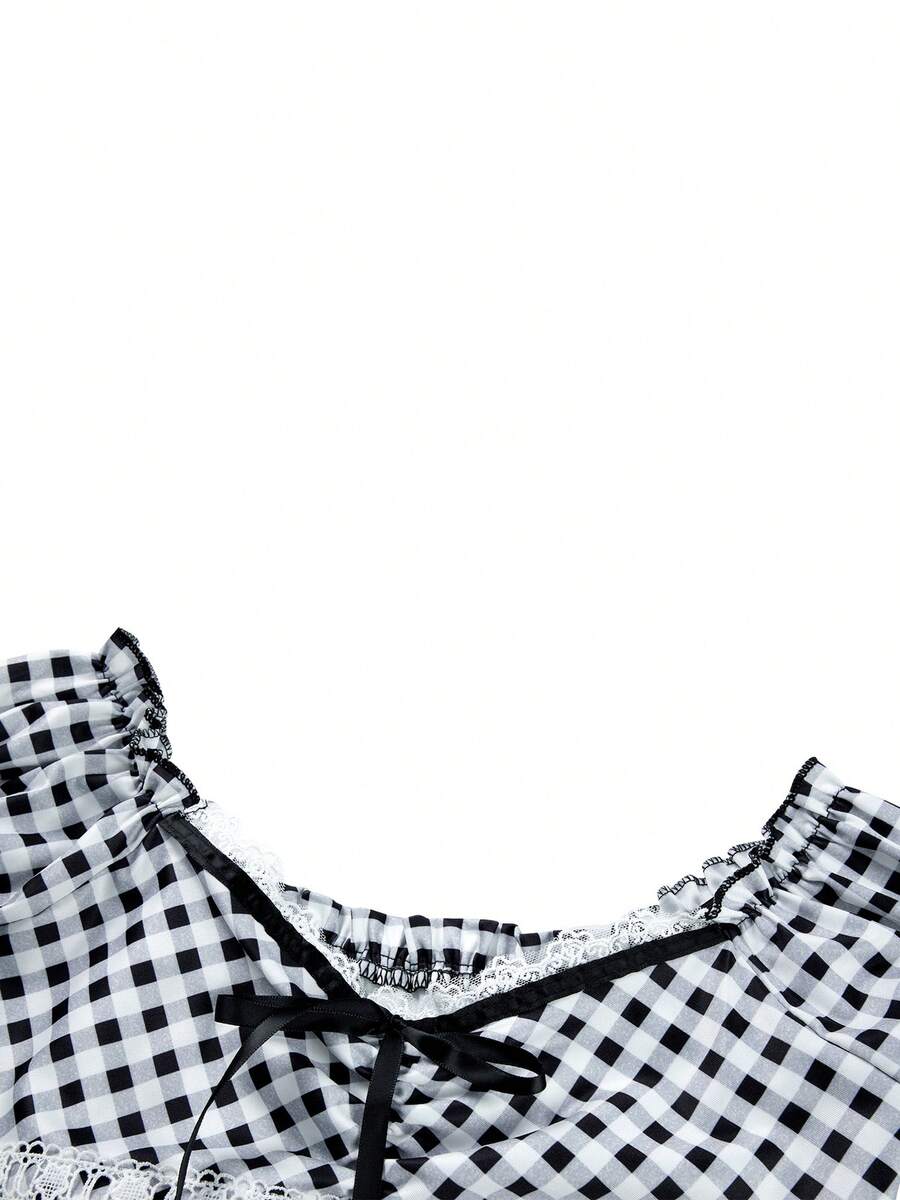 Women's black and white plaid short sleeve blouse featuring a tie-front front bow, contrast lace frill trim, raglan sleeves, and sweetheart neckline.