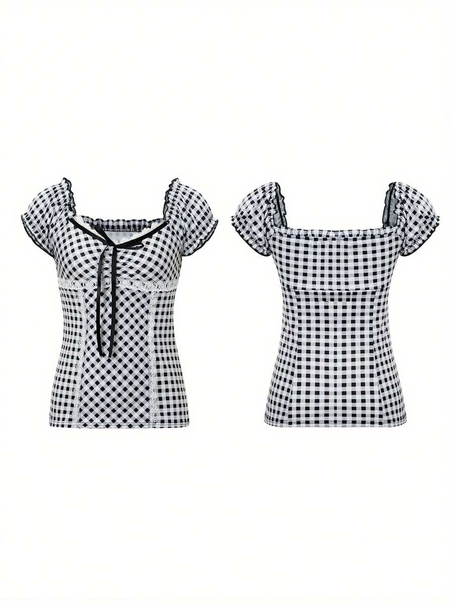 Women's black and white plaid short sleeve blouse featuring a tie-front front bow, contrast lace frill trim, raglan sleeves, and sweetheart neckline.
