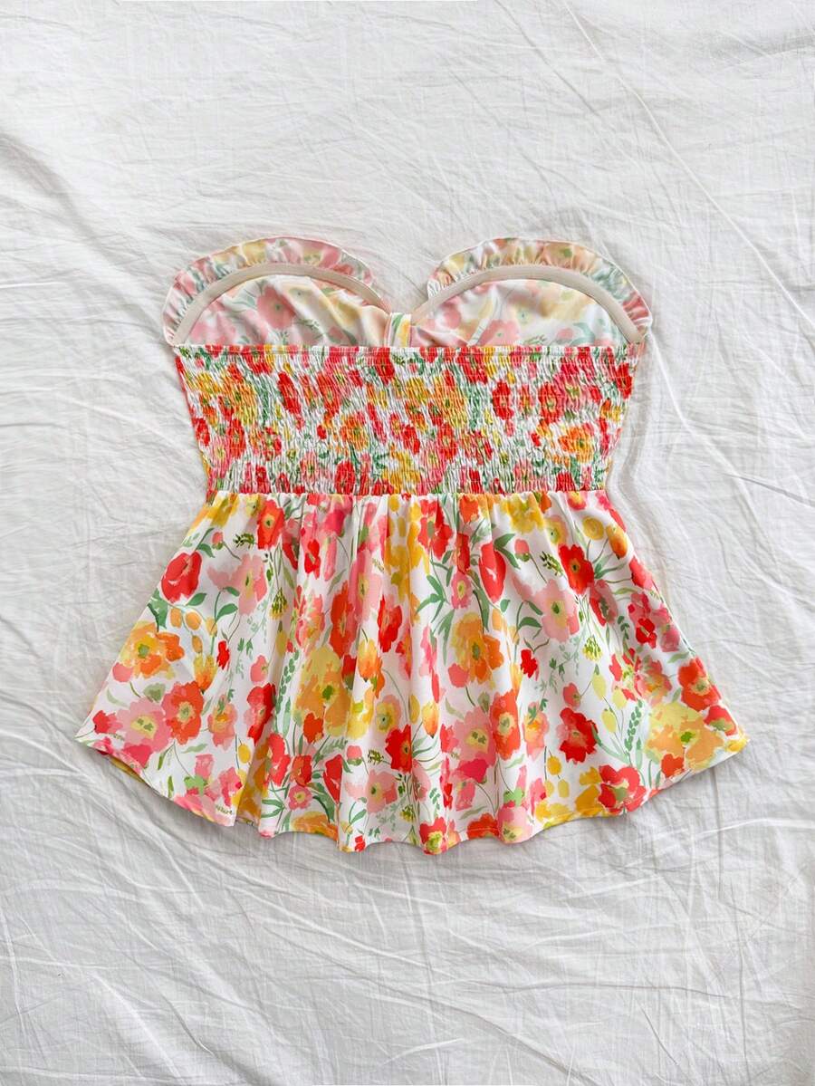 Women's woven strapless bandeau top in multicolor floral print featuring ruffle trim, frill details, and a flared hem.