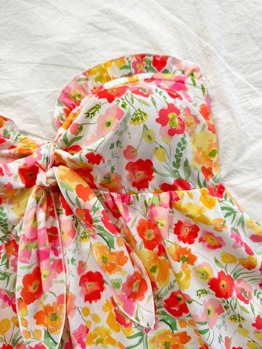 Women's woven strapless bandeau top in multicolor floral print featuring ruffle trim, frill details, and a flared hem.