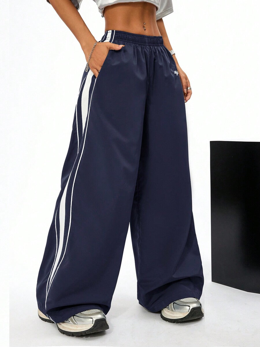 Women's navy blue wide leg sweatpants with casual loose fit, side stripe detail, and elastic waist