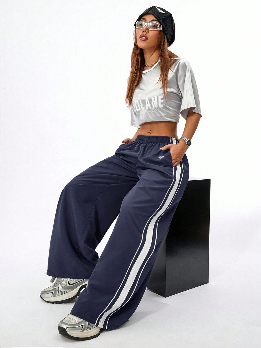 Women's navy blue wide leg sweatpants with casual loose fit, side stripe detail, and elastic waist