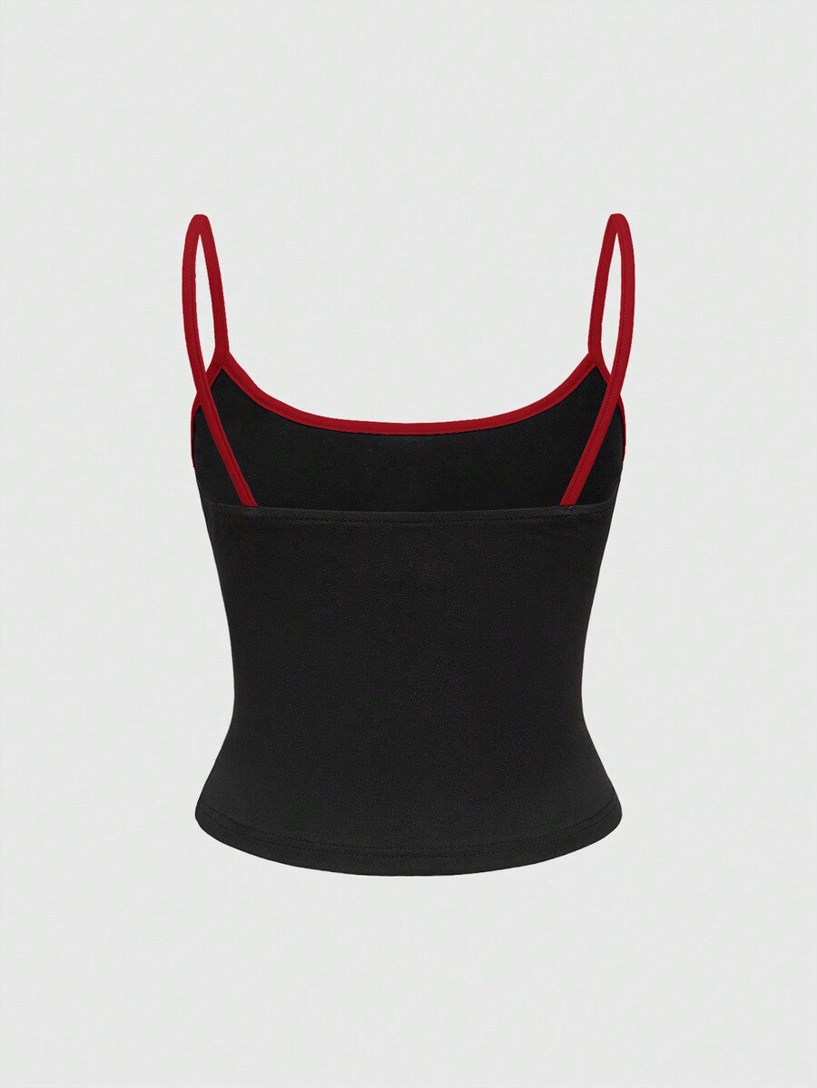Black cropped cami top featuring a graphic print, spaghetti straps, rib-knit fabric with contrast binding, and a slim fit silhouette.